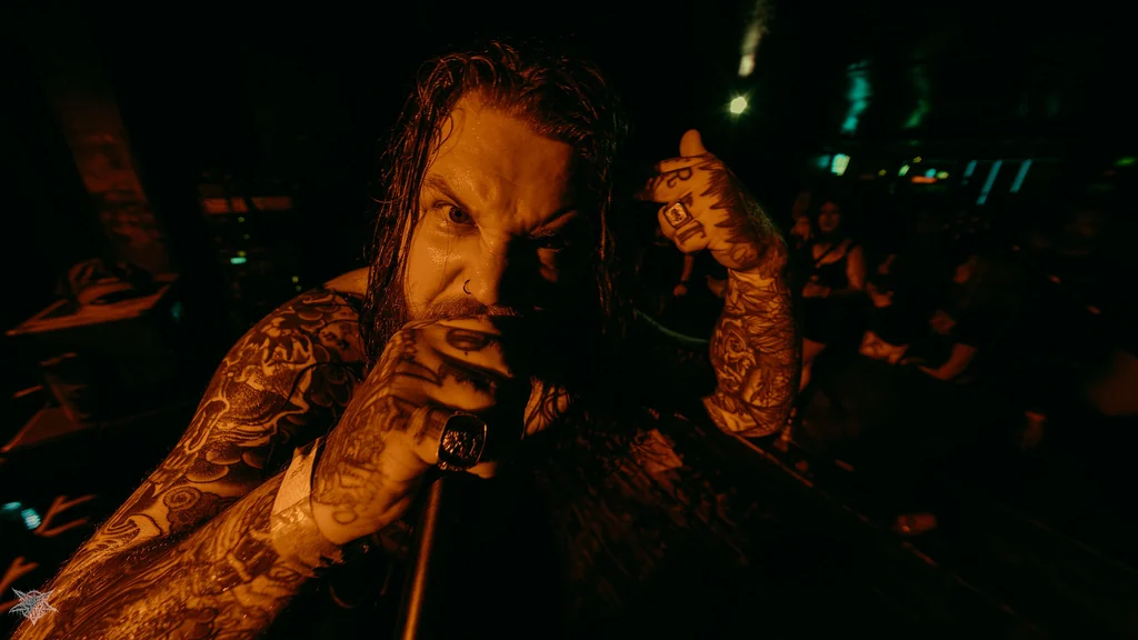 Hated vocalist performing face to face with the camera in warm stage light